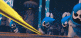 a group of blue cartoon characters are standing next to each other with a yellow beam coming out of their mouths
