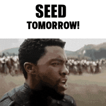 a man is standing in front of a crowd with the words seed tomorrow above him