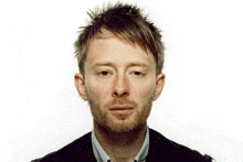 a man with a beard looks at the camera with a sad look on his face