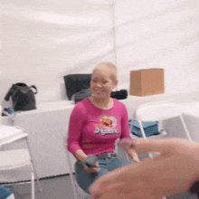 a woman wearing a pink shirt that says stylaro