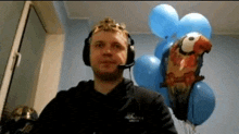 a man wearing headphones and a crown stands in front of balloons