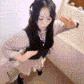 a woman wearing headphones and a dress is dancing in a room .