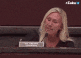 a woman sitting at a desk with a name plate that says ms. greene