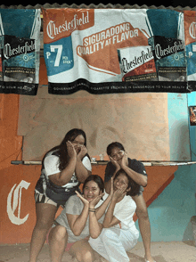 a group of girls posing for a picture in front of a chesterfield sign