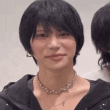 a close up of a woman wearing a necklace and a black jacket .