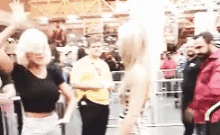 a woman is dancing in front of a crowd of people in a crowded room .