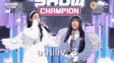 two girls singing in front of a sign that says " show champion "