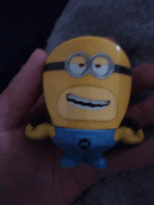 a person is holding a yellow minion with a blue shirt on