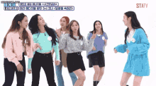 a group of girls are dancing in front of a sign that says statv on it