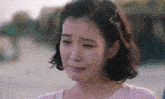 a woman is crying with her eyes closed and her mouth open
