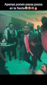 a man in a suit and tie is dancing at a fiesta