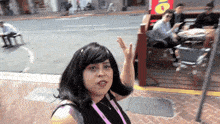 a woman stands in front of a sign that says ' oio '