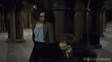 a movie poster for fantastic beasts shows a couple walking