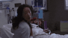a woman is laying in a hospital bed with a stethoscope around her neck .