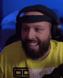 a man with a beard is wearing headphones and a yellow shirt that says ec on it