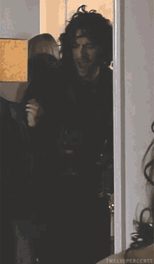 a man is holding a glass of wine in front of a mirror with twelve percent written on the bottom