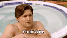 a shirtless man sitting in a hot tub says fuck you