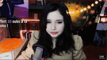 a woman wearing headphones is sitting in front of a microphone and a sign that says 1246 subscribers
