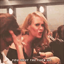 a woman is talking to a man in a crowd and says you shut the fuck up