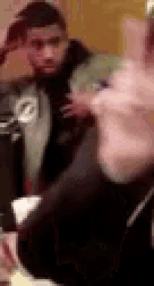 a blurry picture of a man and a woman standing next to each other .