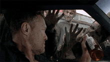 a man sitting in a car with a bottle of beer in his hand