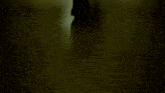 a man in a suit is walking down a dark hallway