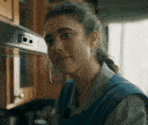 a close up of a woman 's face in front of a stove