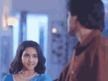 a man and a girl are looking at each other in a living room .