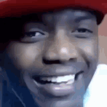 a close up of a man 's face with a red hat on .