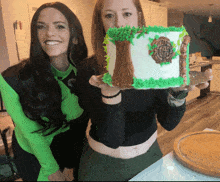 a woman holding a cake with a tree and a celtic symbol on it