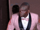 a man in a pink tuxedo and bow tie has the hashtag @oocllibertadores on the bottom