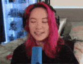 a woman with pink hair is wearing headphones and a nose ring