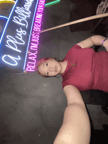 a woman is taking a selfie in front of a neon sign that says a plus billiards