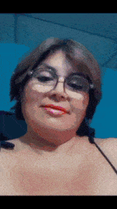 a woman wearing glasses and red lipstick is smiling