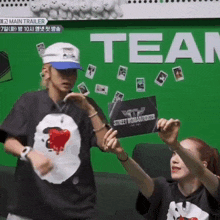 a couple of people standing in front of a sign that says team