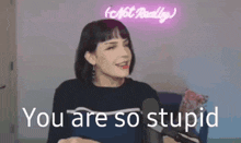 a woman is sitting in front of a microphone and says you are so stupid
