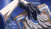 a person in a black glove is holding a blue and gold book