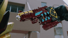 a red and yellow toy gun with the letters s and t on the side
