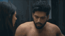 a man and a woman are looking at each other in a bathroom .