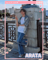 a man leaning against a wall with the name arata on the bottom