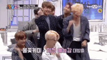 a group of young men are dancing in front of a mnet screen