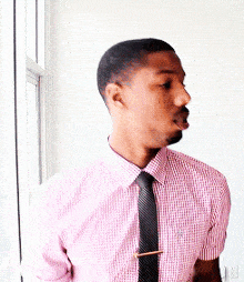 a man with a beard wearing a pink shirt and black tie