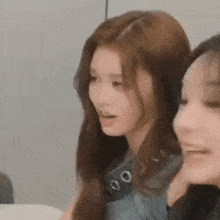 a close up of two women sitting next to each other and smiling .
