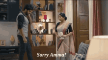 a man and a woman are standing in a living room and the woman is holding a piece of paper and says sorry amma