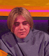 a young man with blonde hair is wearing a turtleneck sweater
