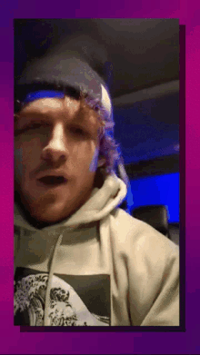 a man wearing a beanie and a hoodie has a picture of a wave on his shirt