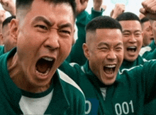 a group of men wearing green jerseys with the number 001 on them are laughing and celebrating .