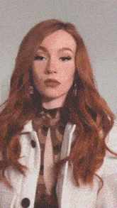 a woman with red hair is wearing a white coat .
