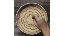 a person is making a swirl design on a cake with a spoon .