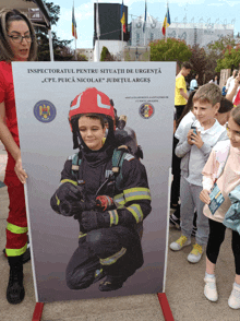 a picture of a boy in a fireman 's uniform is displayed on a stand